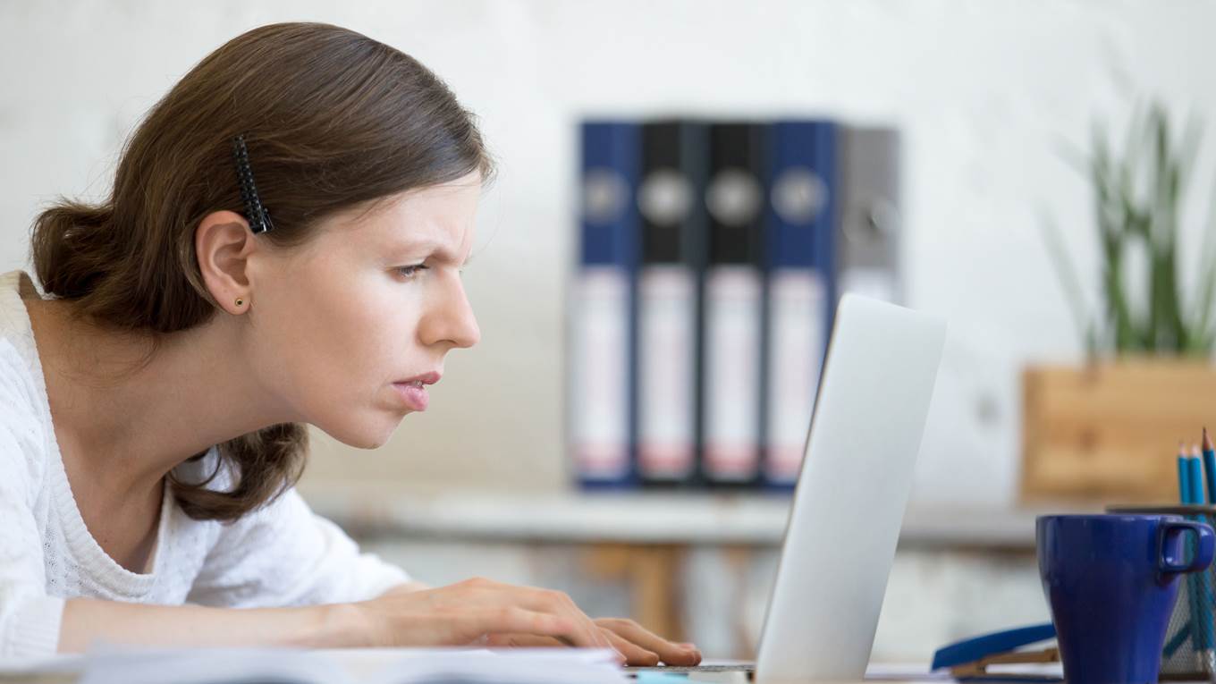 concerned woman looks at laptop