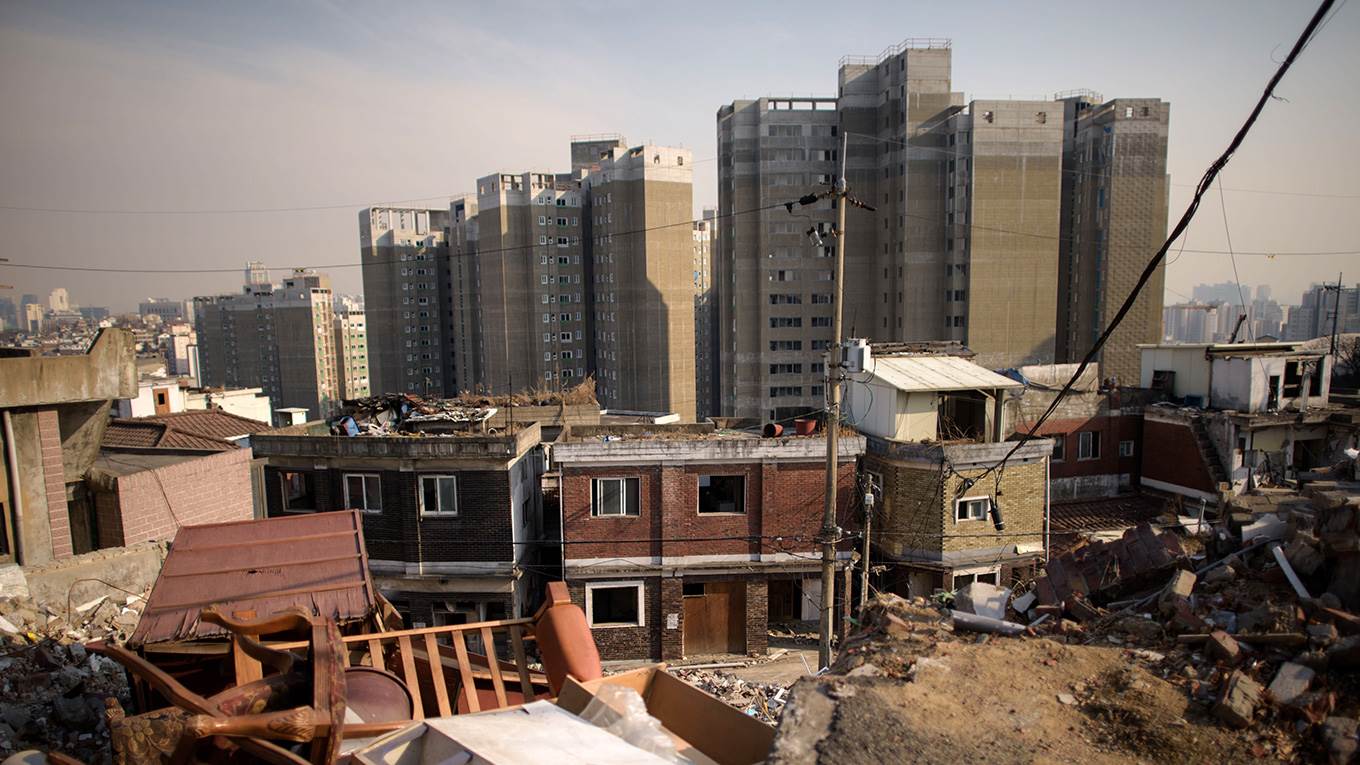 New apartment blocks rising behind a demolished neighborhood in central Seoul