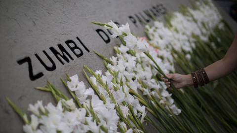 A woman places a flower at a monument in memory of Zumbi dos Palmares, a leader of resistance against slavery in Brazil, during Black Awareness Day celebrations in Rio de Janeiro, Brazil, on November 20, 2017.