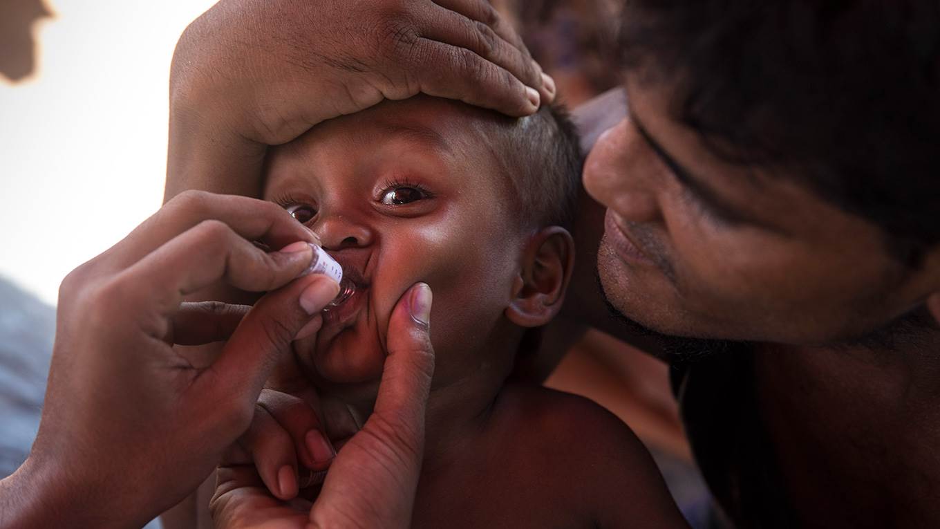 Vaccinators give the oral cholera vaccine to Rohingya