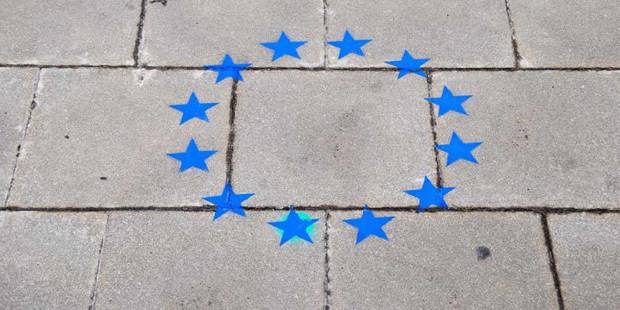 European Union star insignia painted on concrete wall.