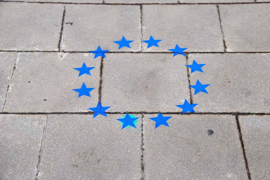 European Union star insignia painted on concrete wall.