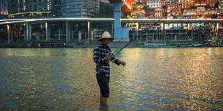 A fisherman stands in the water of the Yangtze river 