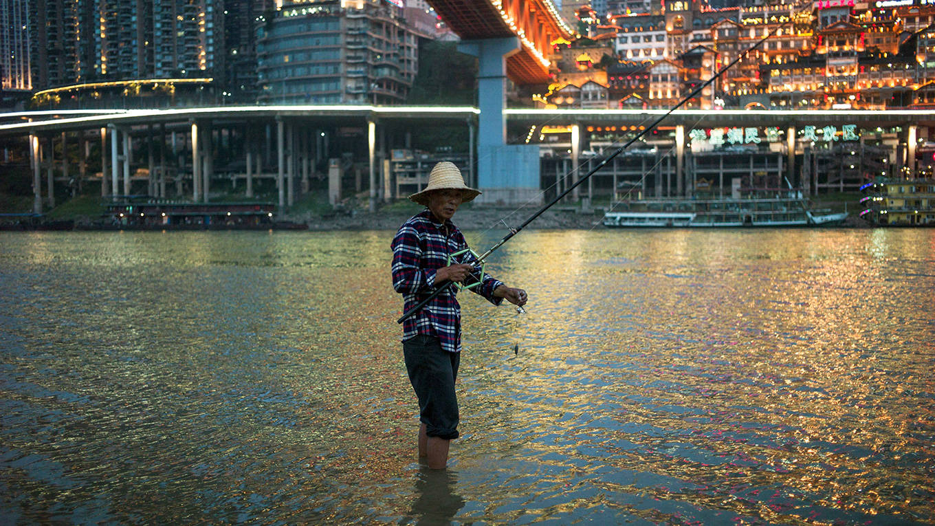 A fisherman stands in the water of the Yangtze river