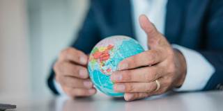 businessman holds globe