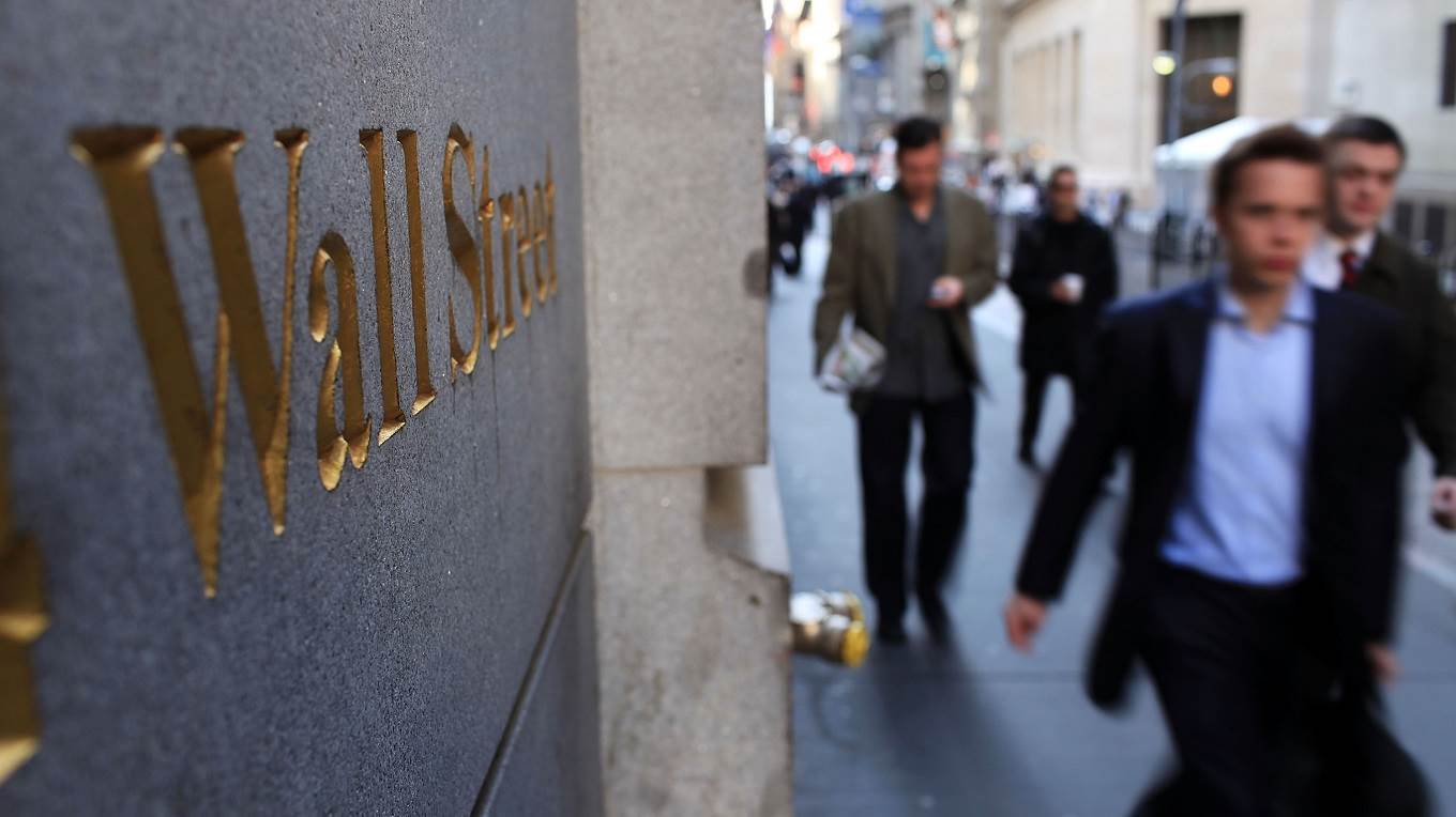 People walk along Wall Street in the financial district in New York City
