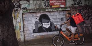 varoufakis66_MAURO PIMENTELAFP via Getty Images_bolsonarocoronavirusgraffiti