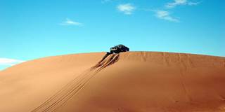 Sand dune in Morocco with jeep at top