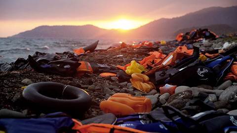 Refugee maritime debris on Mediterranean shore.