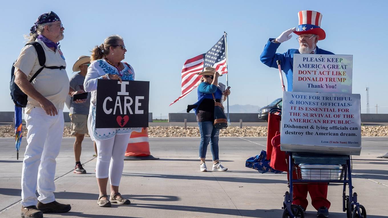 Leon Blevins, dressed as Uncle Sam, salutes other attendees during the 'End Family Detention' event 