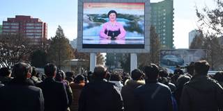 Pyongyang residents watch a big screen near the Pyongyang Railway Station 