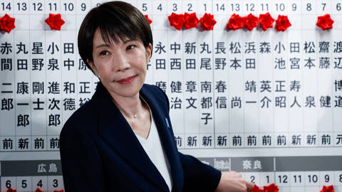 Japan’s Prime Minister Sanae Takaichi placing a red paper rose on the name of an elected candidate at LDP headquarters during Japan’s Lower House election on February 8, 2026, in Tokyo.