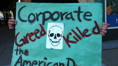Corporate greed protest sign