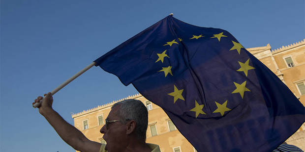 protester with EU flag outside Greek parliament