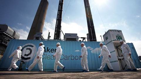 Scientists stand beside a new carbon capture test unit 