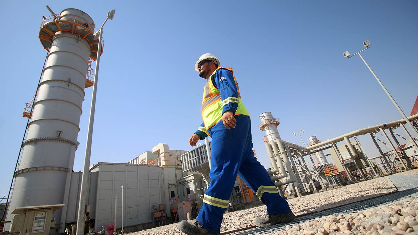 An employee walking at the Rumaila natural gas powerstation