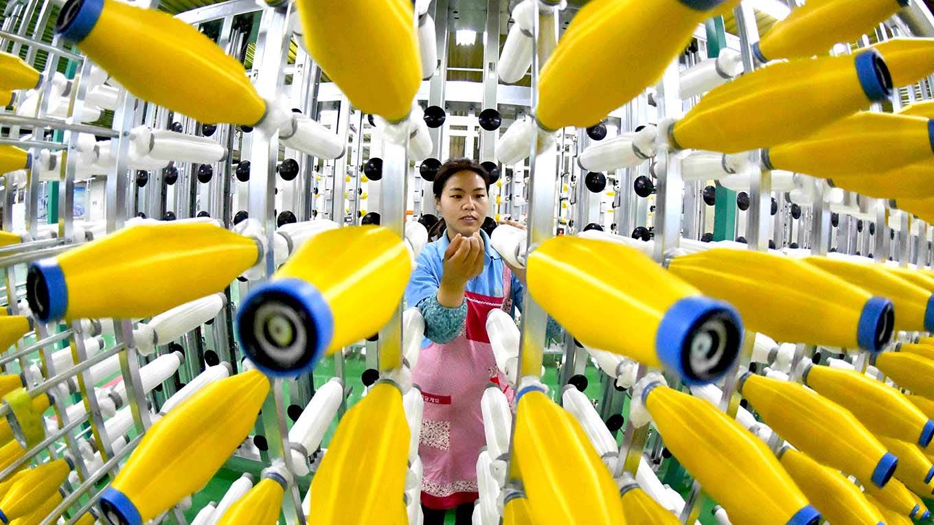 An employee works at a chemical fiber weaving company