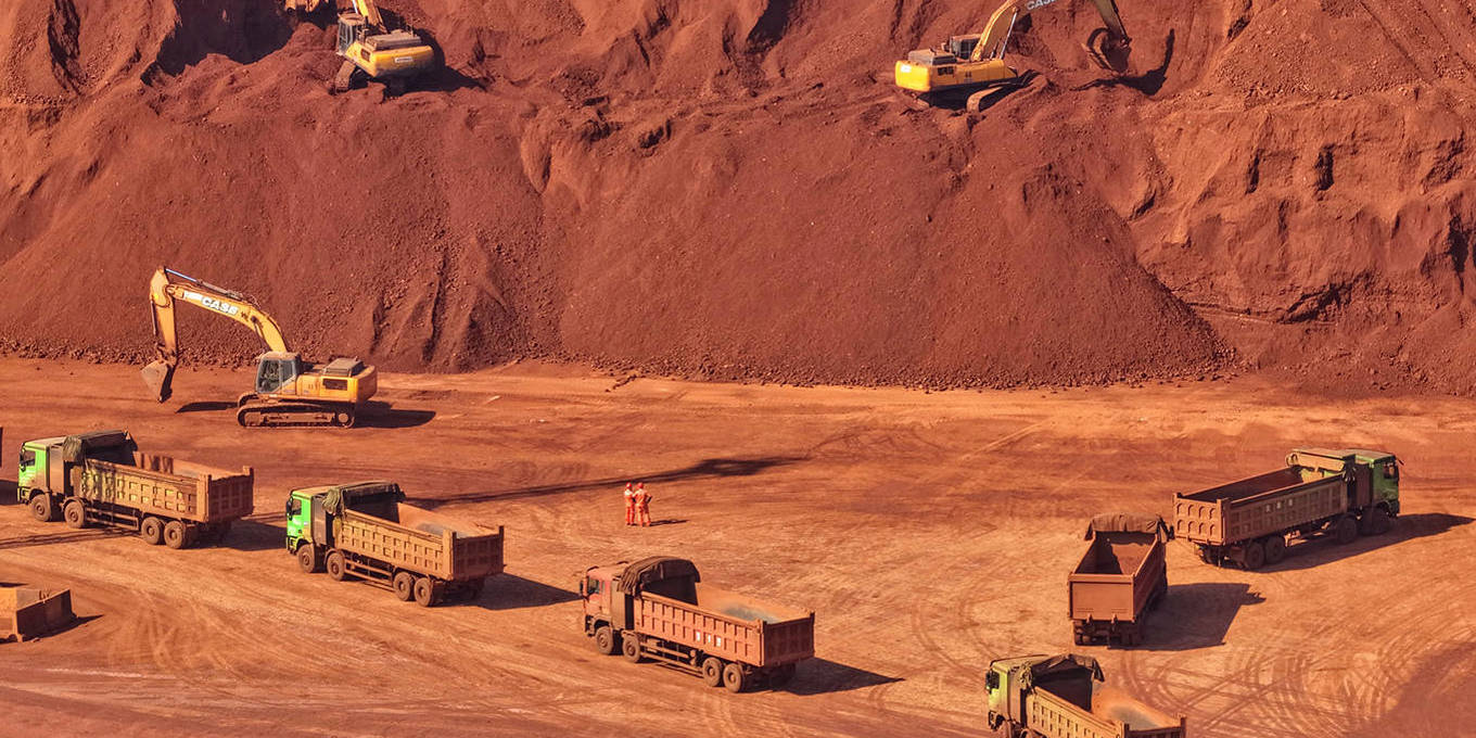 Trucks line up to be loaded with imported bauxite ore at a processing facility in Yantai, China