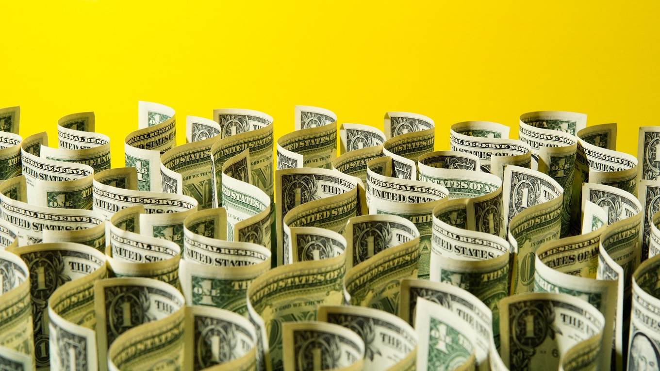 Many curled US 1 dollar bills on edge