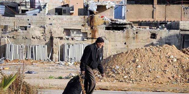 Man in demolished neighborhood in Syria