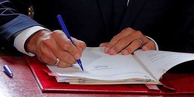 Macron signs a document