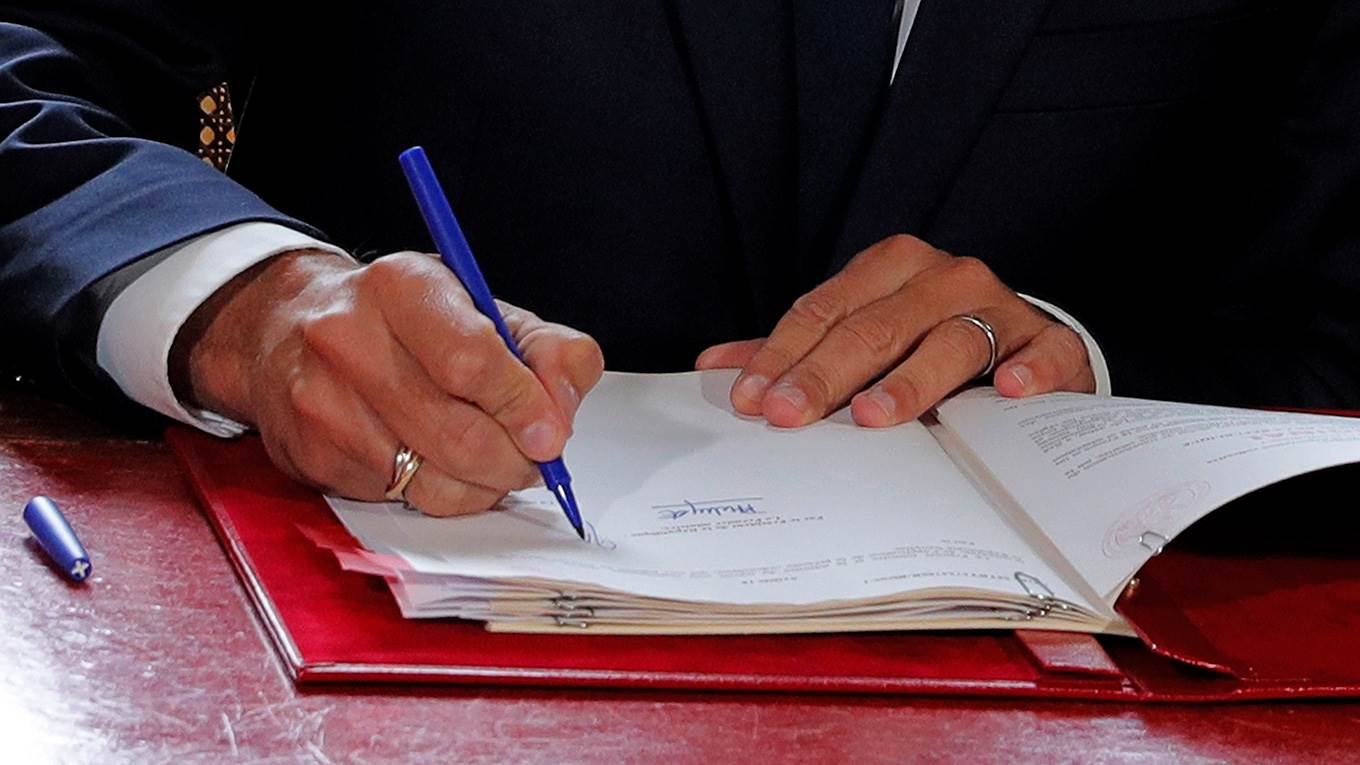 Macron signs a document