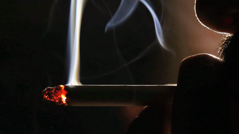 A close up shot of a man smoking a cigarette