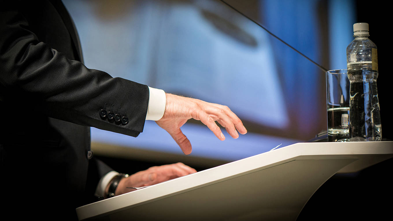 delong211_JasminMerdanGettyImages_businessmanatpodiumhand