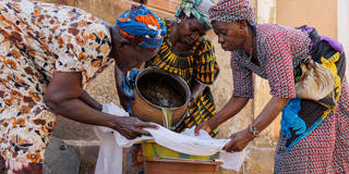 Women filter oil extracted from shea nuts to produce shea butter in Siby, Mali, on March 21, 2023, illustrating the role of women in the shea industry that supports millions of people across West Africa.