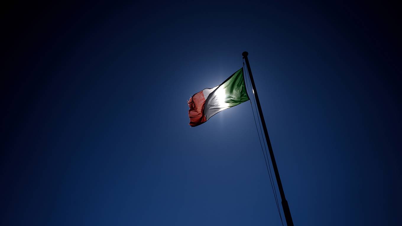 padoan1_FABRICECOFFRINIAFPGettyImages_Italianflaginfrontofsun