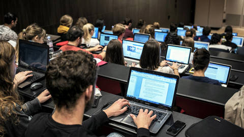 Students of the University of Lyon use laptops to take notes in a classroom