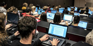 Students of the University of Lyon use laptops to take notes in a classroom