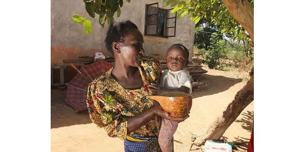 African Woman Feeding Child