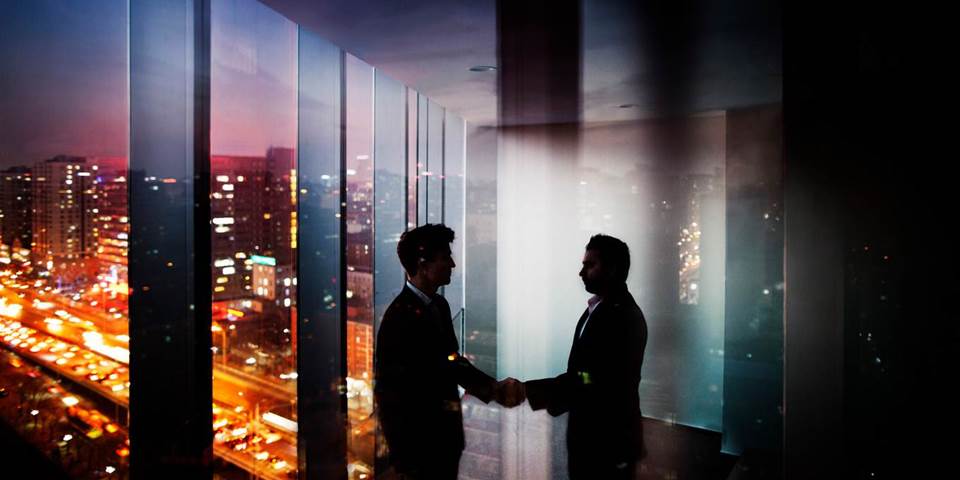businessmen shake hands night