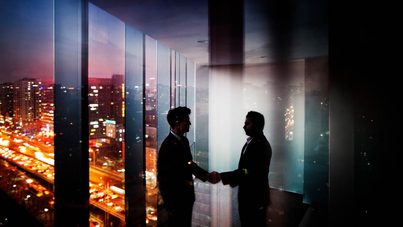 businessmen shake hands night