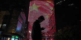 A man looks at his phone near a giant image of the Chinese national flag 