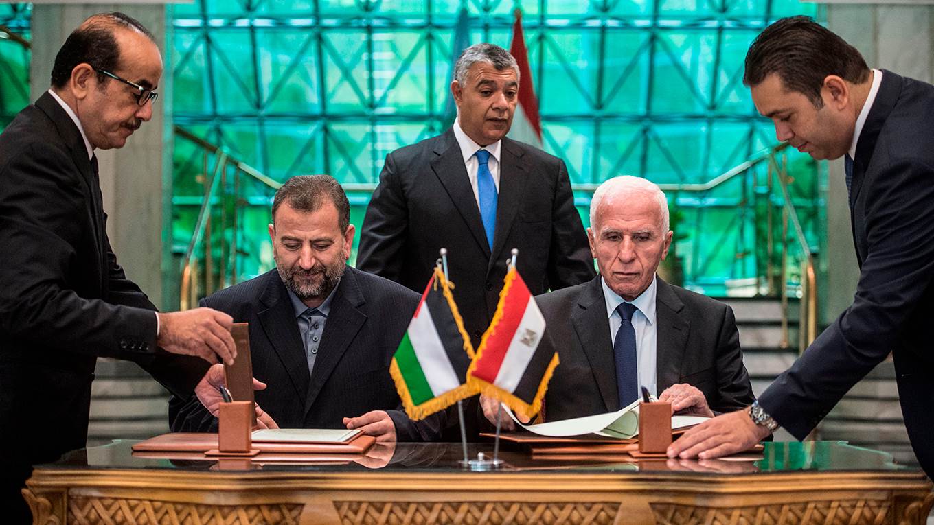 Fatah's Azzam al-Ahmad and Saleh al-Aruri of Hamas sign a reconciliation deal