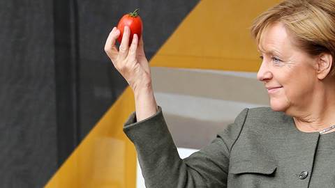 Angela Merket holds up a tomato
