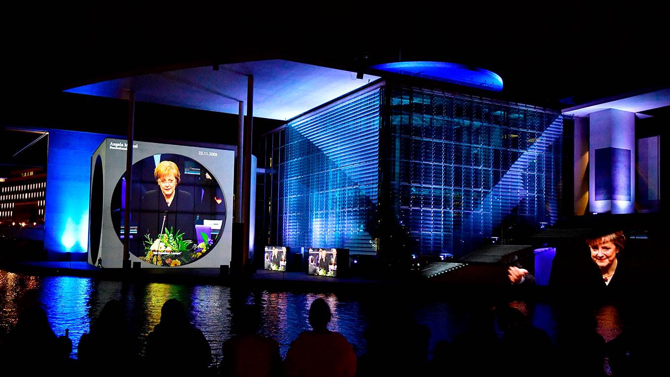 Visitors watch German Chancellor Angela Merkel