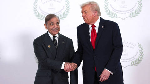U.S. President Donald Trump and Pakistani Prime Minister Shehbaz Sharif shake hands as they pose for a photo during a world leaders' summit.