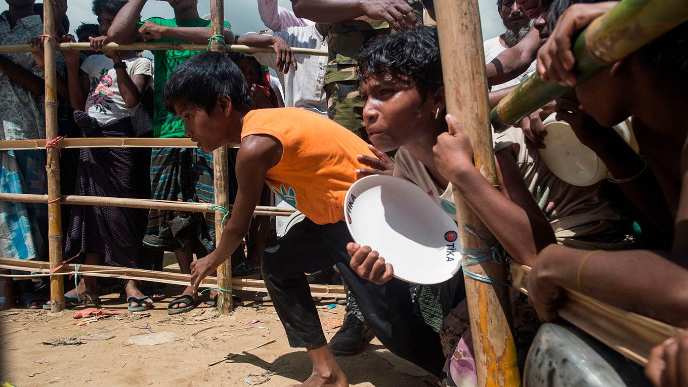 Rohingya Muslim refugees run to receive food