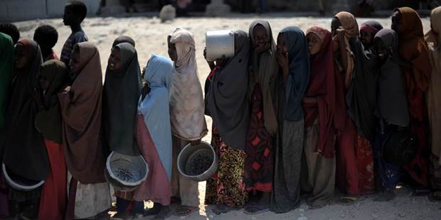 Somali girls wait in line to receive a hot meal at a food distribution point in Somalia's capital Mogadishu