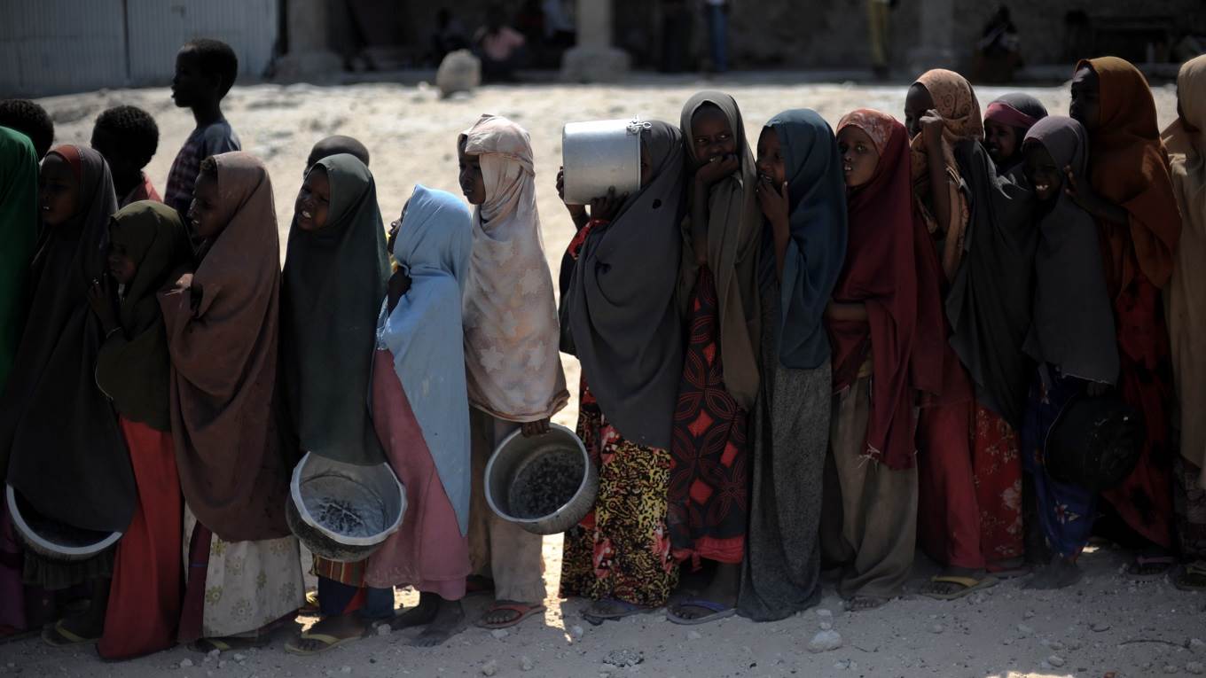 Somali girls wait in line to receive a hot meal at a food distribution point in Somalia's capital Mogadishu