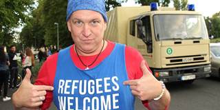 German male with 'Refugees Welcome' shirt on.