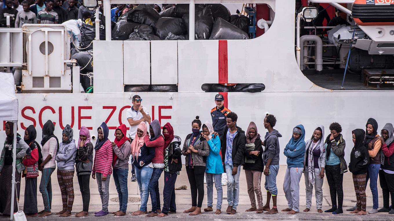 Migrants disembark the Italy's coastguard ship Diciotti at the port of Catania