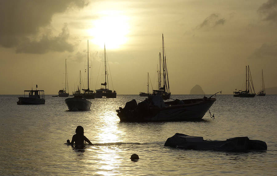 Woman in water amidst boats