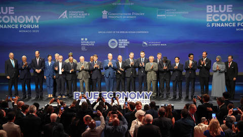 Participants, including France's President Emmanuel Macron (C-L) and Prince Albert II of Monaco (C-R) pose on stage at the end of the Blue Economy and Finance Forum (BEFF) ahead of the Unoc3, at The Grimaldi Forum in Monaco.