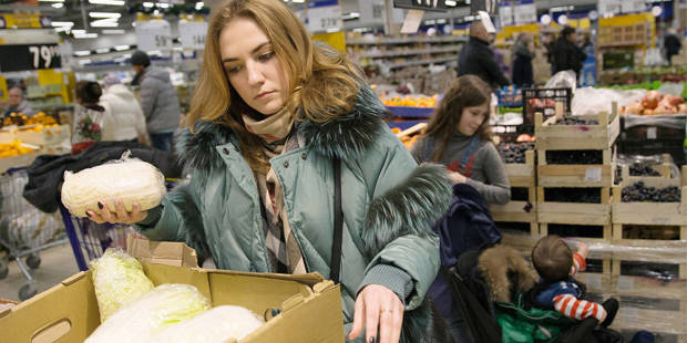 A customer choosing lettuce at a Lenta supermarket in Russia
