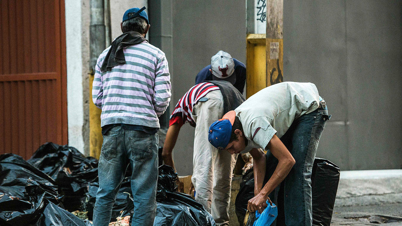 People scavange for food in the streets of Caracas