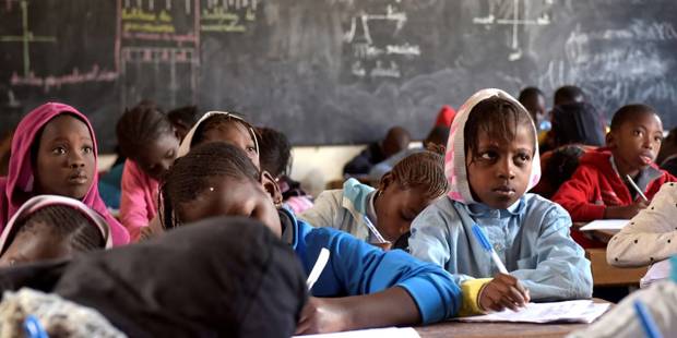 Pupils write on their notebook as they attend class at a primary school in Pikine